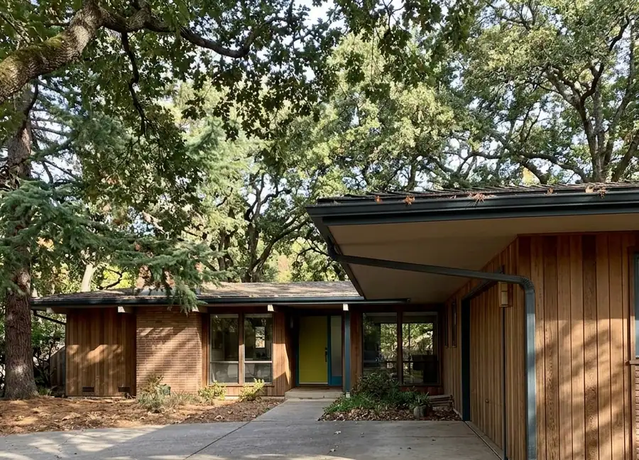 Mid-century Carmichael home with mature oak canopy and extended roofline — gutter cleaning in Carmichael